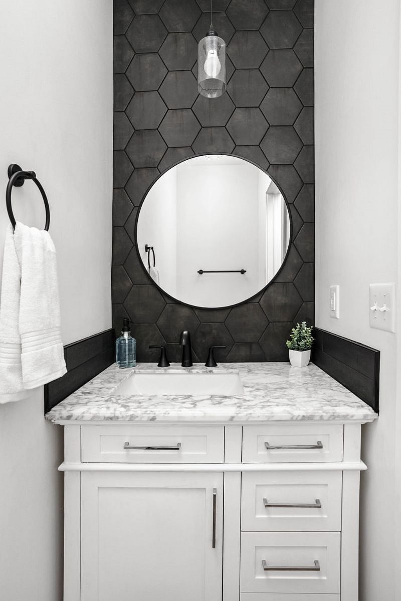 Our well-appointed half-bathroom featuring an elegant mirror, sink, vanity cabinet, and fresh towels.