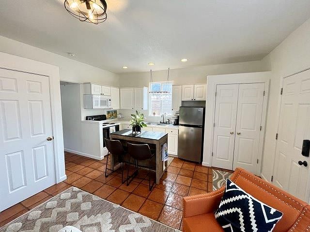Kitchen open to living room with island and 2 bar stools