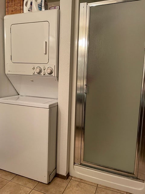 In bathroom there is a washer and dryer as well as a stand up shower.