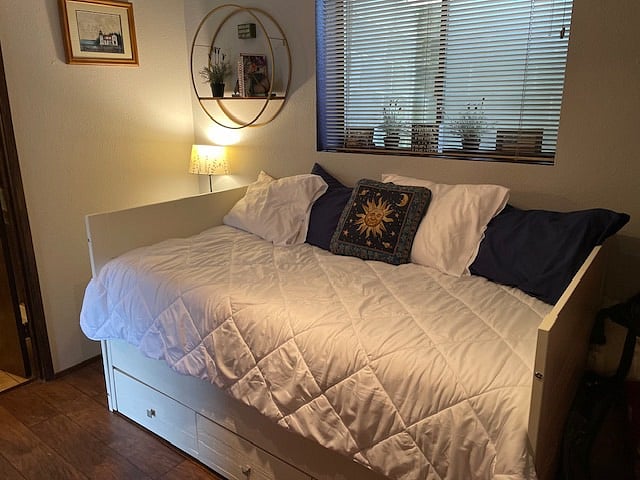In bedroom, twin day bed with trundle bed and storage underneath.