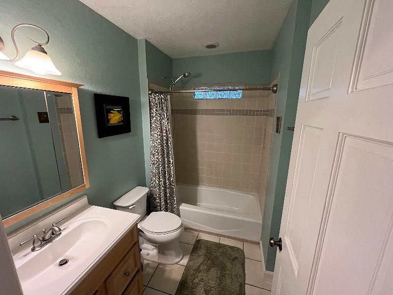 Bathroom with tile and hotel shower bar.