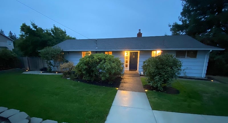 Ramp to front door. Large front yard.There is a fence and landscaping wall around three sides of the front lawn.