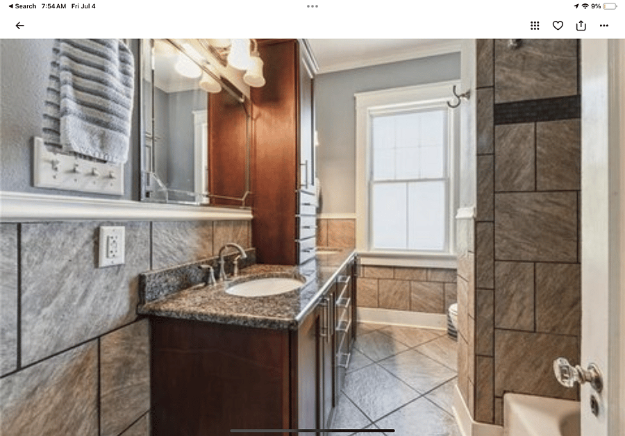 This bathroom with double sinks, tub and shower is closest to bedroom one