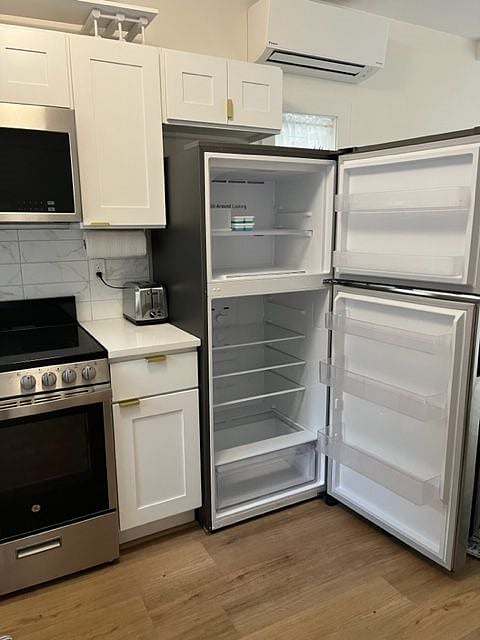 Small, but full-sized refrigerator holds gallon milk/ juice containers in door.