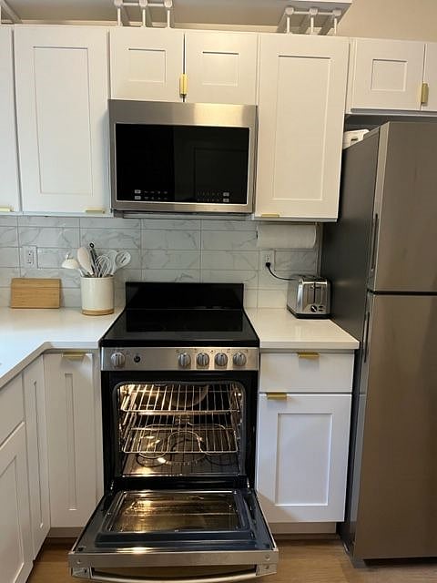 Small, but good capacity electric range for cooking, plus oven and above range microwave and hood vent combo.