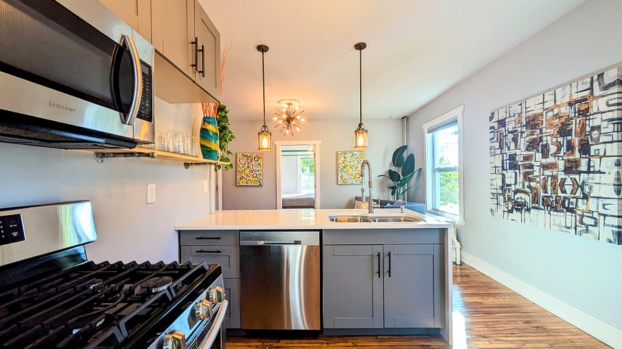 Stunning kitchen with gas range, stainless appliances and quartz countertops with waterfall edge