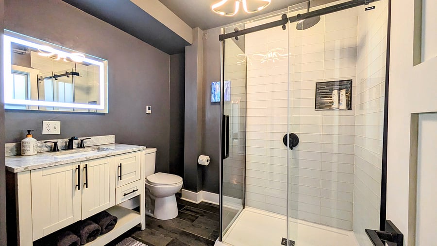 Relax in the spacious bathroom with rainfall shower, heated floors, backlit mirror and marble vanity