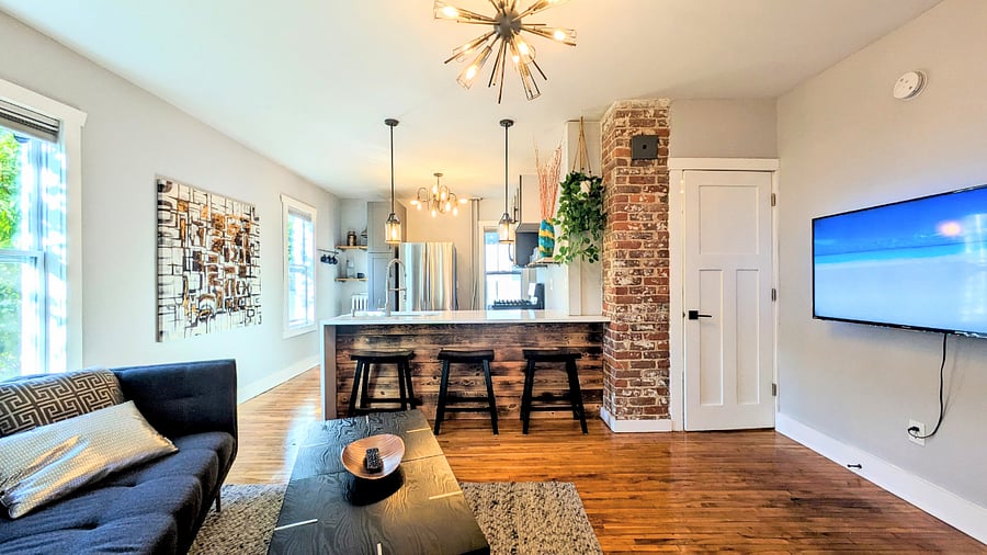 Open kitchen and living room with unique burnt wood feature wall