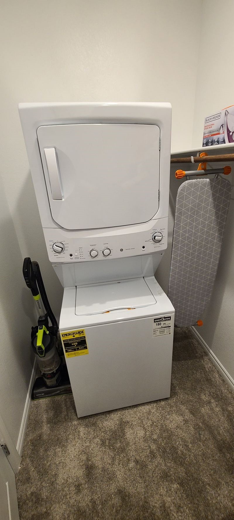 Inside washer/dryer unit in an oversized closet. There is a full sized ironing board with iron. Also, a vacuum in unit for personal housekeeping. 