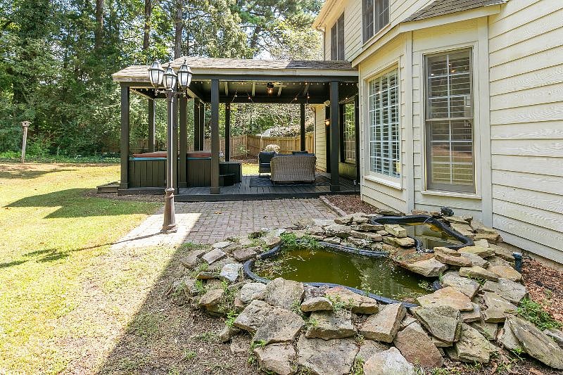 Backyard has a hot tub, patio and deck