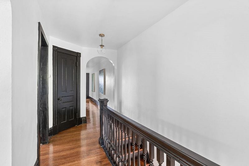 Hallway - View from living room. The door to the king bedroom is on left, the middle door is a utility closet, and the arched way leads to the queen bedroom, kitchen, bathroom and back staircase to the basement for the washer and dryer