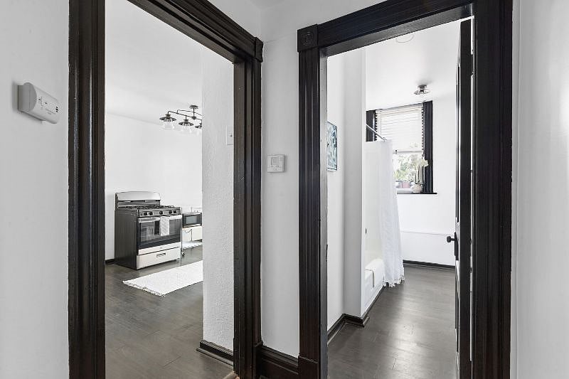 Hallway - view of entrance to kitchen on left and bathroom on right. The thermostat for the central heat is on the corner wall between the 2 entrances.