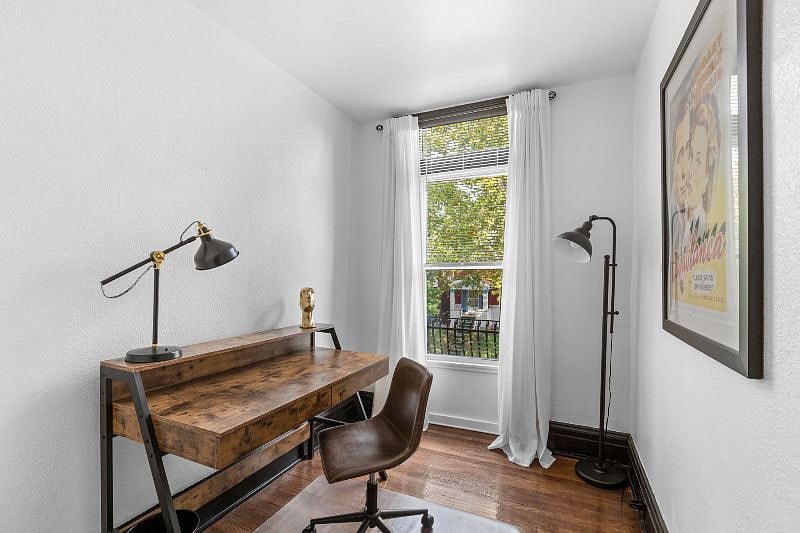 Study - view from entryway showing workstation: desk, lamp and swivel chair.
