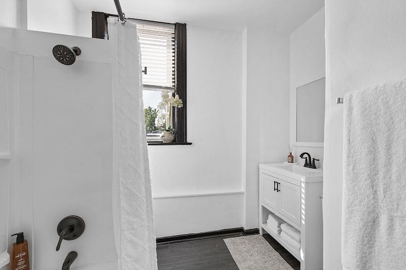 Bathroom - view of tub with shower and vanity.