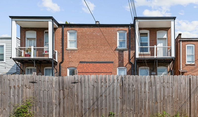 View of the back of the building with covered balconies (52A is the top right) and fence.