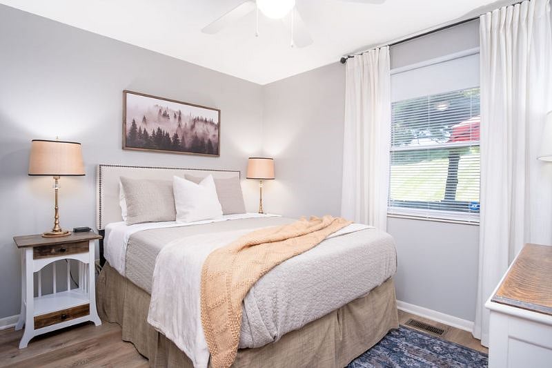 Rear bedroom with queen bed, 2 nightstands, dresser, smart tv, black out shade and curtains, and large clothes closet.