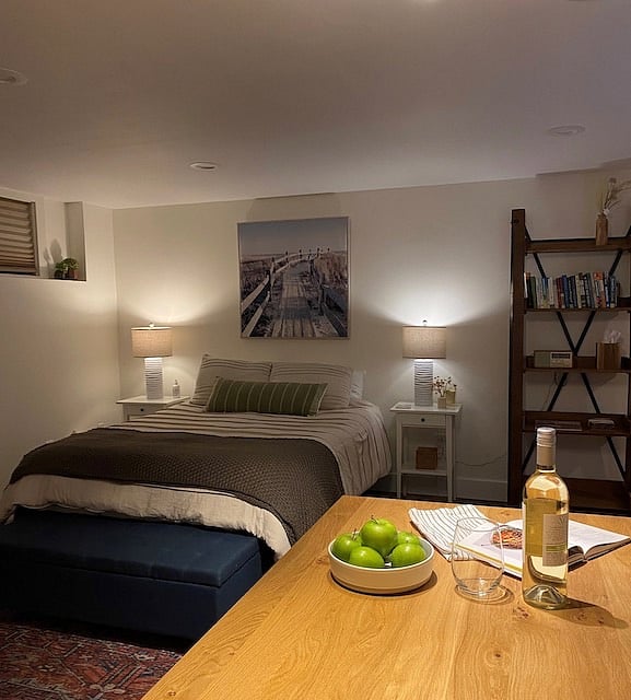 View of queen bed with two bedside tables and reading lamps. Fully furnished with 2 sets of queen sheets, extra blankets and down alternative comforter.