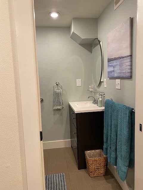Entry view of bathroom with toilet and shower to the left, sink in front.