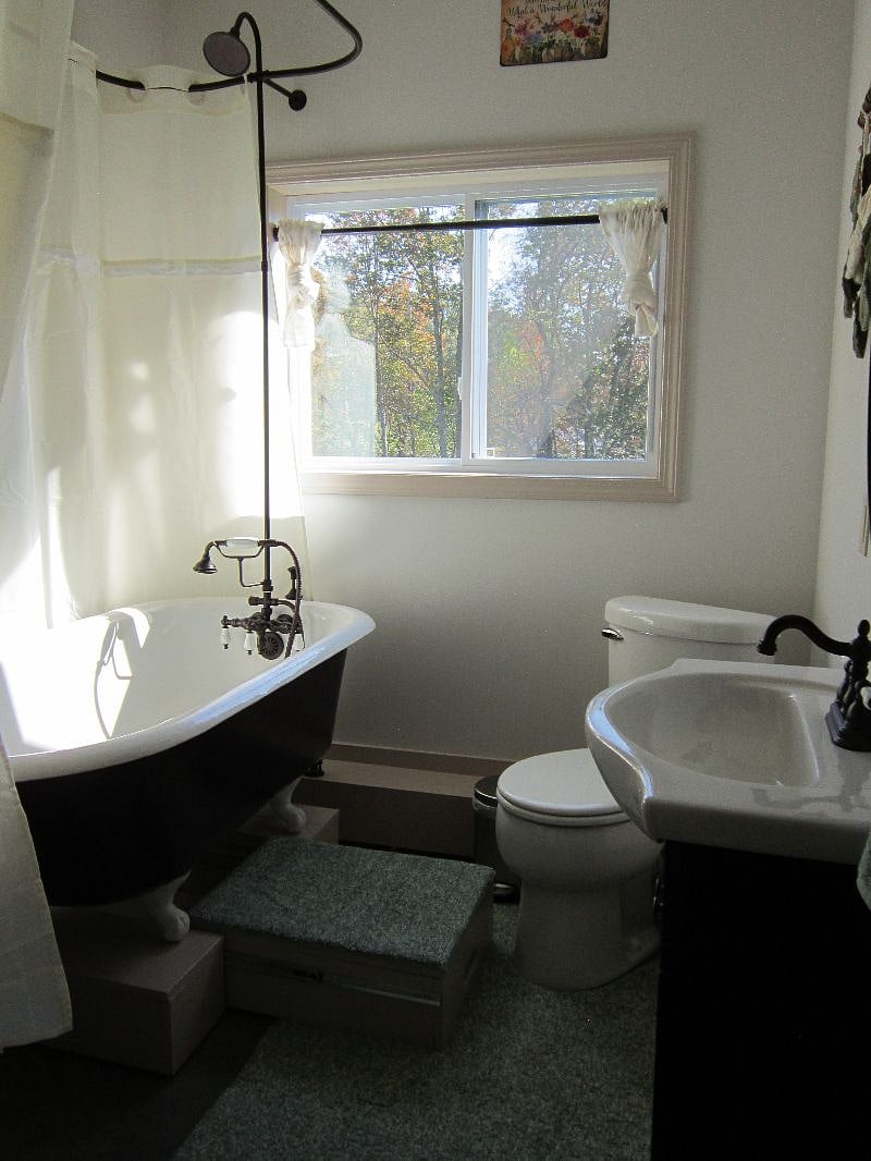 drawer beneath tub pulls out for a step because tub had to be raised up to accommodate plumbing