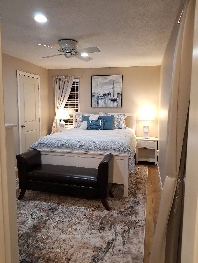 3rd bedroom- ceiling fan, closet, dresser, TV, iron, ironing board, bench