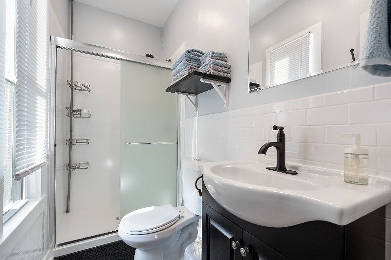 The bathroom is stocked with towels and has a tall shower caddy with lots of storage.