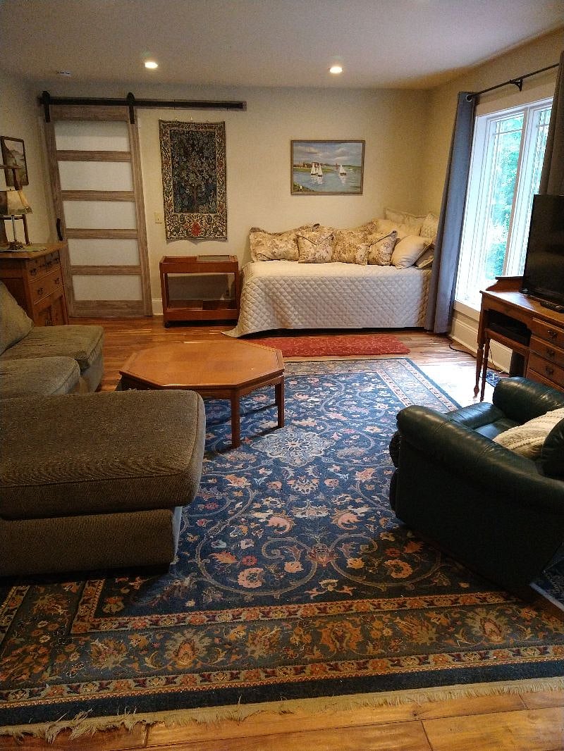 Living Room - Unit 1 with better picture of two single beds (on the right side by window with beige cover).