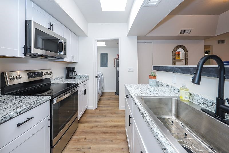 Galley style kitchen with laundry room off of it with new high end washer and drier and sliding pocket door to keep noise down