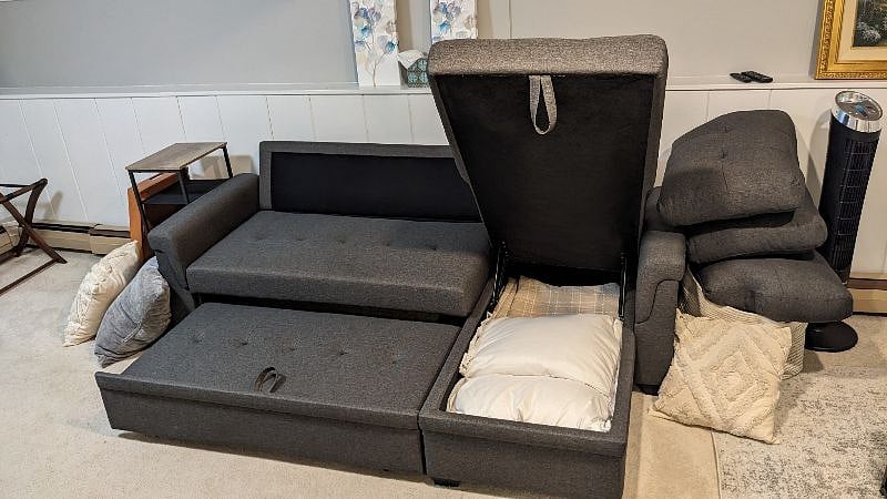 Extra pillows and blankets are hidden within the couch.