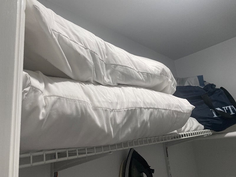 Closet with extra pillows, blankets and sheets, personal fan games to play extra hangers