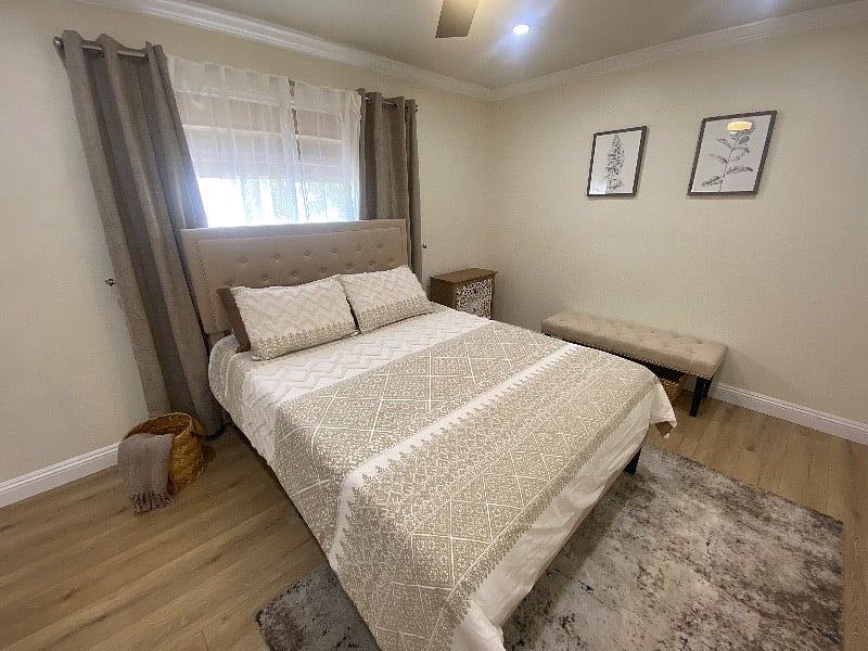 Spacious primary bedroom with queen bed and natural light for a restful stay.