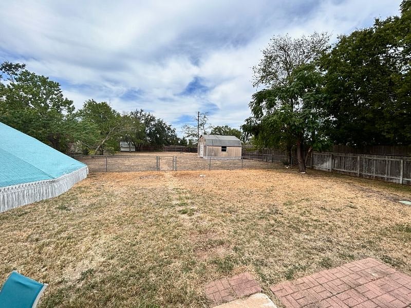 The backyard which goes beyond the chain linked fence back to the wood fence