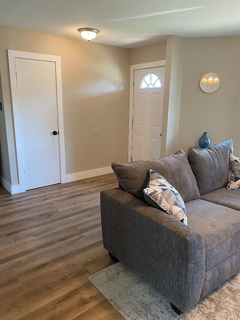 View of front door from living room. Small closet for coats and broom/mop.