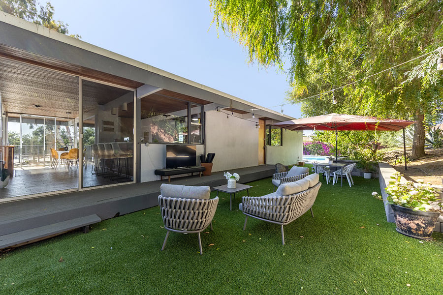 Shaded backyard with Google home speakers, Smart TV and outside dining for 4
