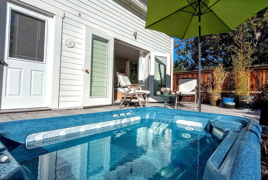 Sunny sunken hot tub with French doors opening out from master bedroom.