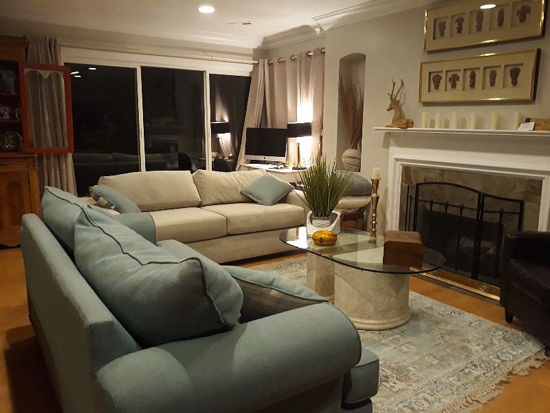 living room with fireplace and white pulkl oiut sofa bed, queenkitcehn