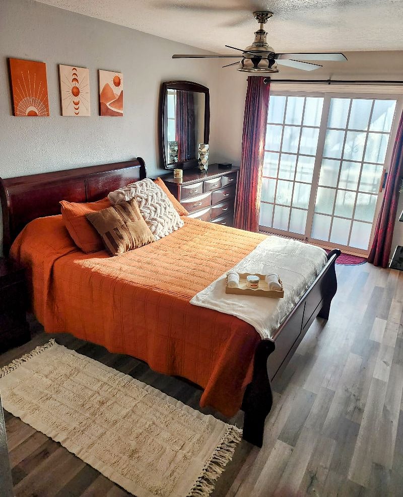 Bedroom with en-suite bathroom. Queen bed. TV/Roku. Darkening curtains (blackout curtains available). Robe hooks on wall, dresser, walk-in closet with shoe rack, and a nightstand.