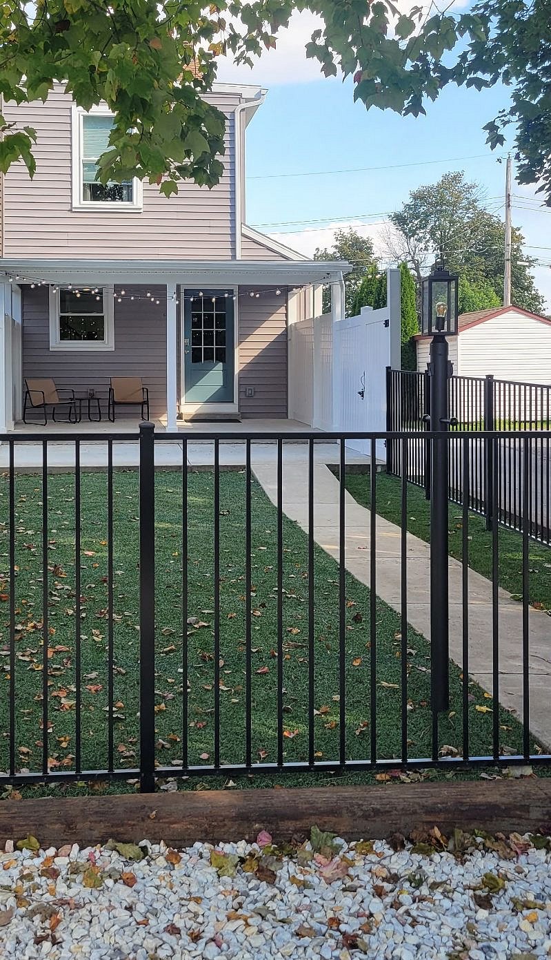 Rear entrance from driveway has a lamp post, fenced yard and dimmable lights at the patio and covered patio