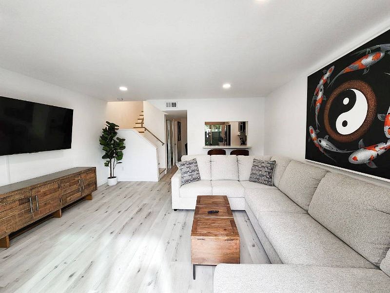Living Room with large 4k Smart TV, L shaped couch, original Thai artwork, and 2 person bar!