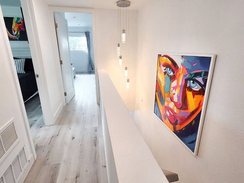 Upstairs hallway with original Thai artwork, thermostat control, and designer Chandelier!