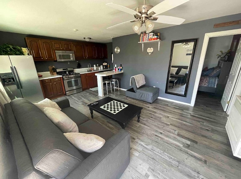 Living room and kitchen area with out book switch (take one and leave one!), games, and a full kitchen. Couch is a pull out bed and tv is on the opposite wall (not seen in this picture)
