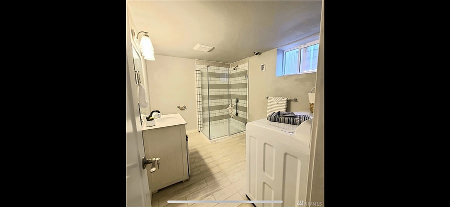 Shared basement bathroom with laundry machines 