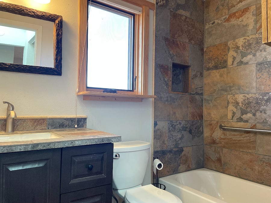 Tile bathroom with window facing backyard