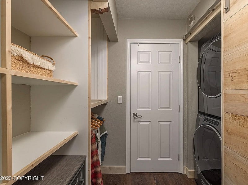 The wide walk-through/dressing room from the bedroom includes the washer-dryer.