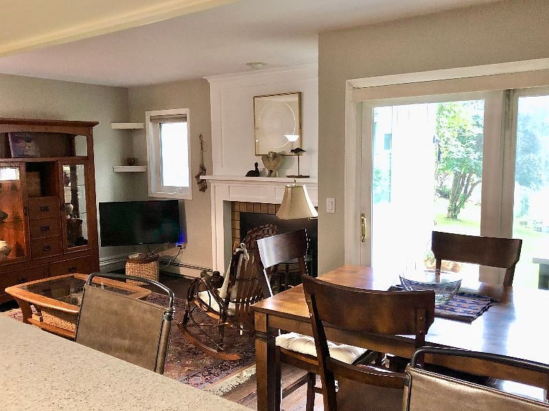 The living rooms open to the dining area located between the kitchen counter and the sliding glass doors to the outside covered porch.