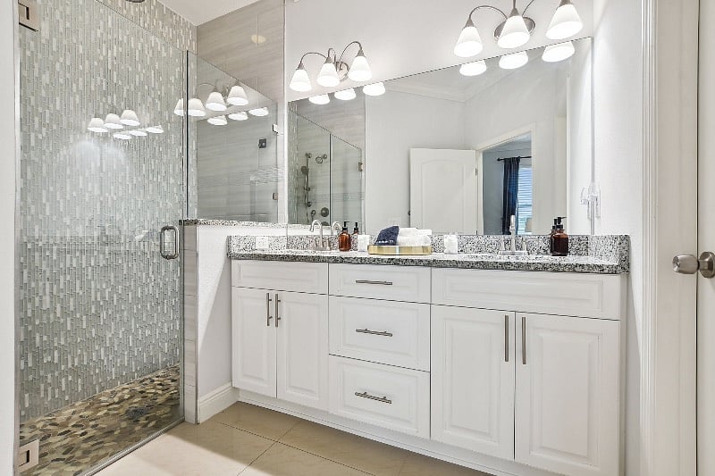 Master Bathroom with double vanity, shower equipped with rain shower head and hose. Shampoo, conditioner and makeup towelettes are available. Water closet located through the right door.