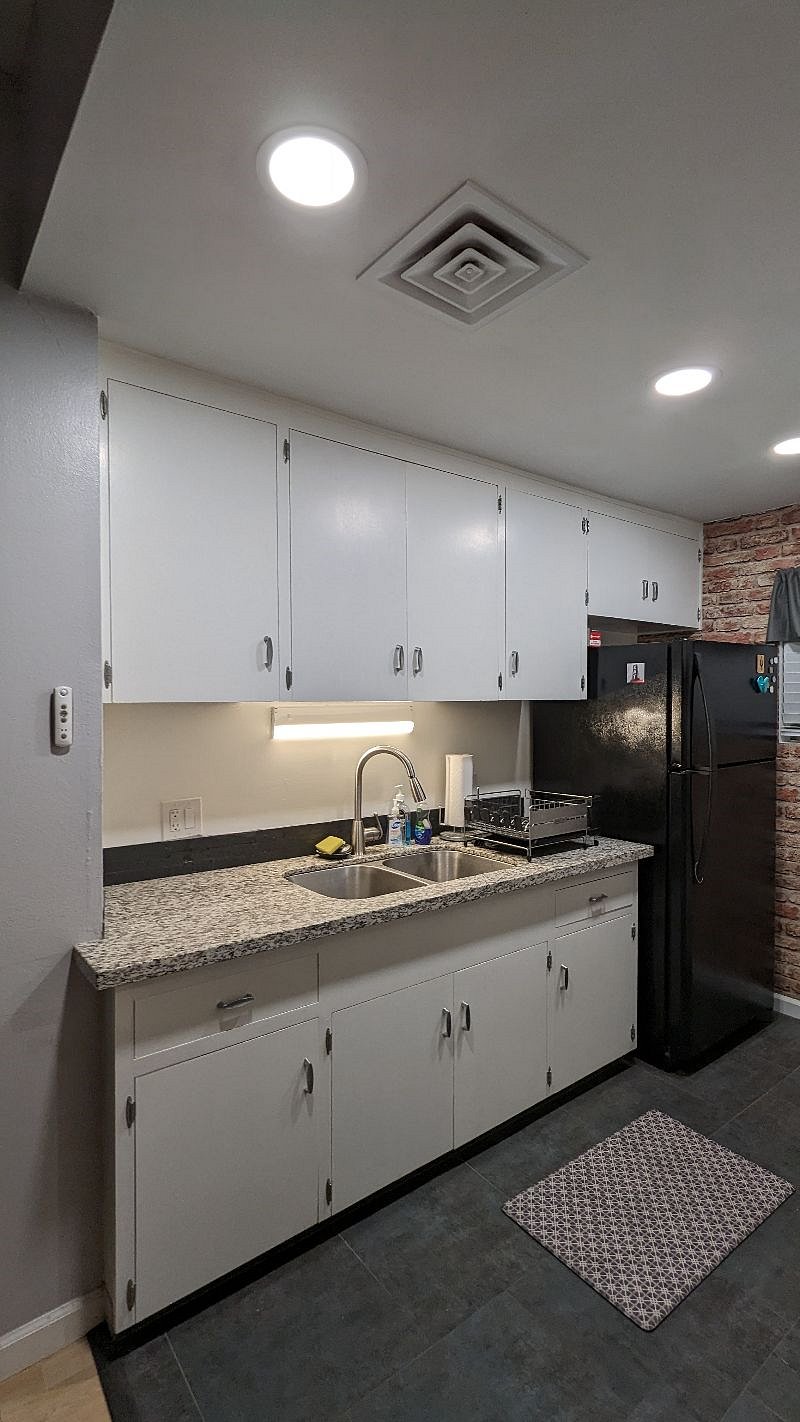 kitchen showing drying dish rack and cleaning supplies.
Plates, bowls, cups above sink. Extra Brita filter next to fridge. (current one is new)