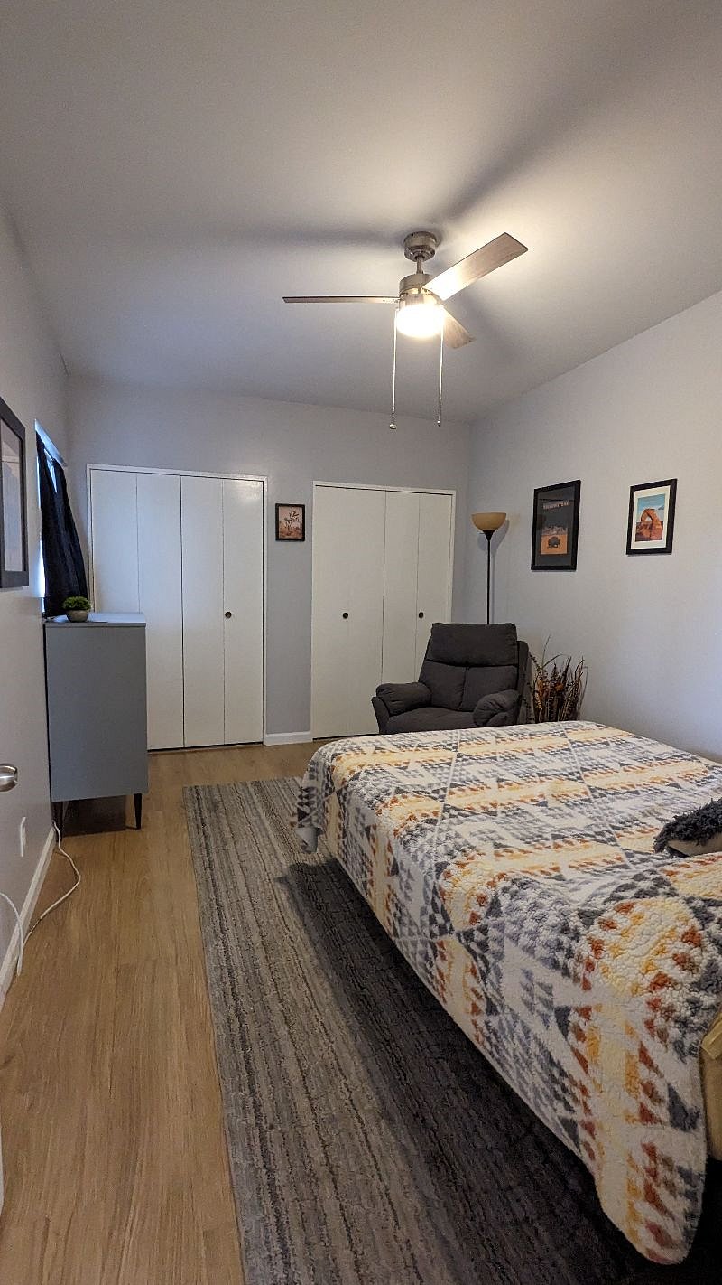 bedroom with closet doors closed and la-z-boy recliner.