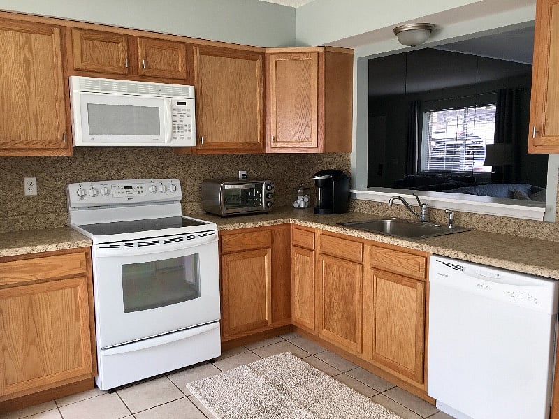 Full size appliances including dishwasher, refrigerator, and coffee maker. Spacious counter areas perfect for meal prep.