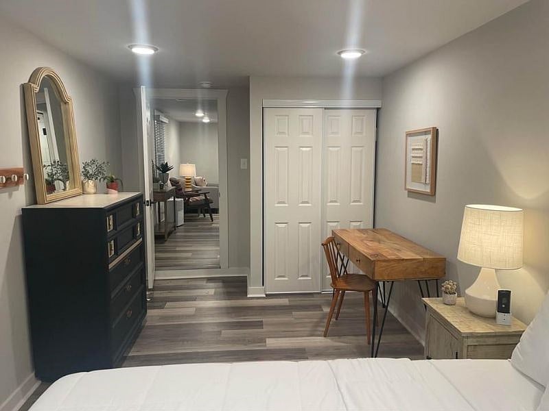 Spacious Bedroom with dresser, queen bed, two nightstands and a desk and chair.