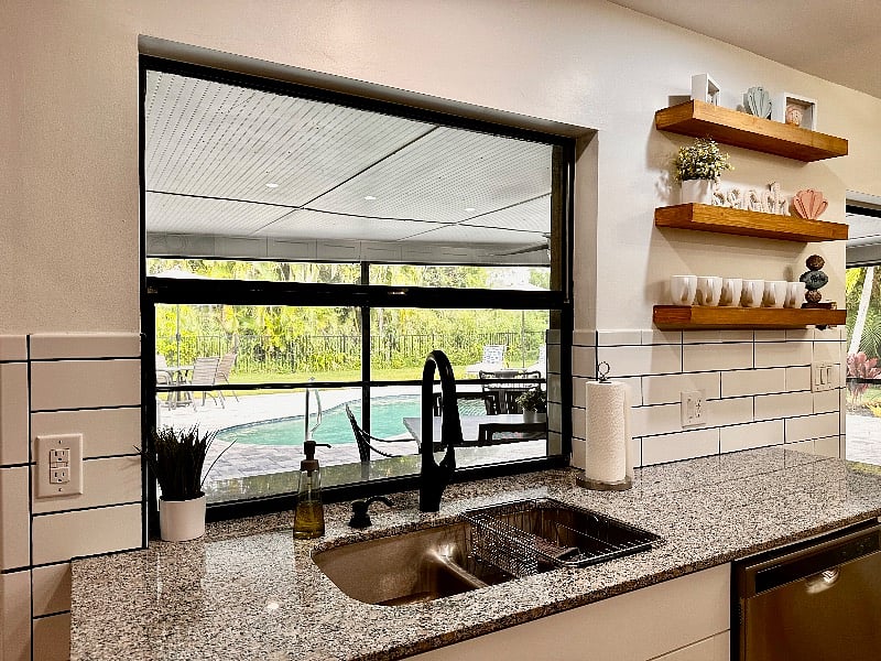 New kitchen sink and granite counters with a pool view